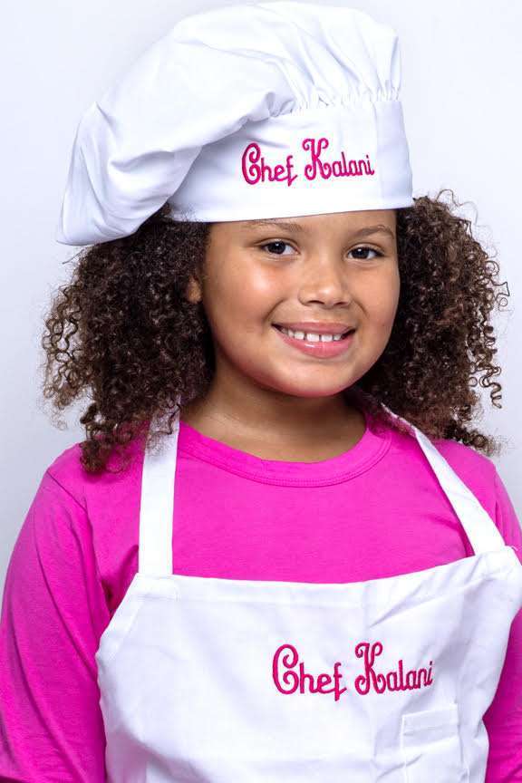 photo of Chef Kalani wearing her cooking apron and chef's hat.